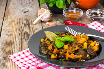 Roasted vegetables with pumpkin and mushrooms on a black plate