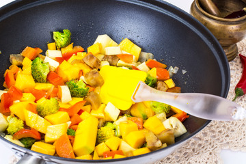 Mix vegetables, stewed in a pan  at home crocheted napkins on a 