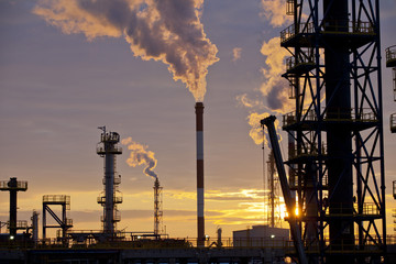Oil Industry Refinery factory at Sunset, Petroleum, petrochemical plant, smoke comes out of  big...