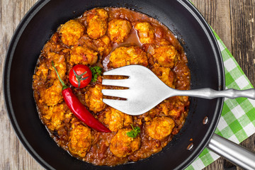 Chicken meatballs with vegetable spicy sauce in the pan