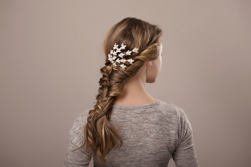 head of woman with hair in bun on gray isolated background