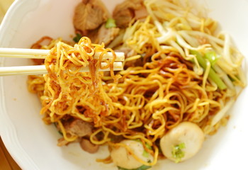 Chinese egg noodle picking in white plastic chopstick