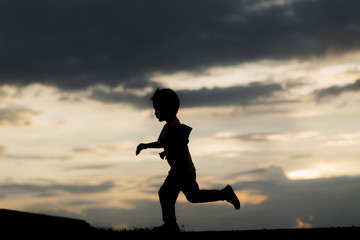 silhouette A kid run at sunset