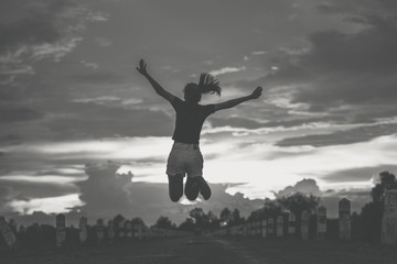 Fototapeta na wymiar silhouette of Happy woman jumping against sunset. Freedom concept. Enjoyment.