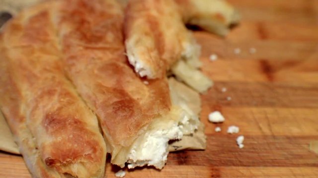 Baked rolled thin sheets of dough with chees filling .