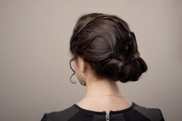 head of woman with hair in bun on gray isolated background