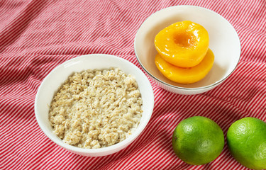 Nutritious breakfast: oatmeal and slices of peaches. Food photo