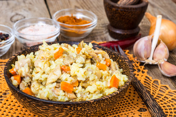 Pilaf with meat, rice and zira in a wooden bowl