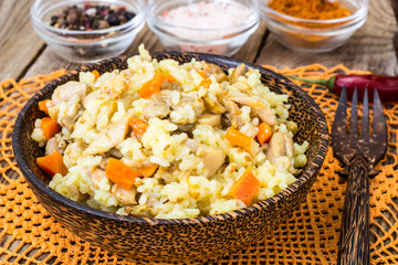 Pilaf with meat, rice and zira in a wooden bowl