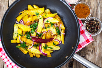 Fried potatoes with pumpkin and red onion