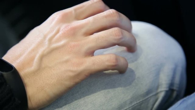 Persona stressata e impaurita si tocca le gambe nervosamente durante il volo dentro un aereo
