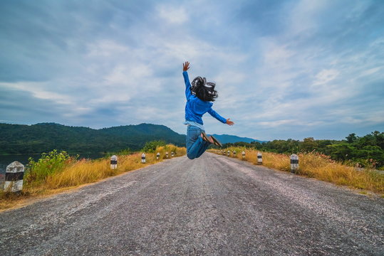 Beautiful girl jumping on the rural road