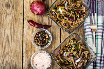 Marinated mushrooms and onions in a glass salad bowl