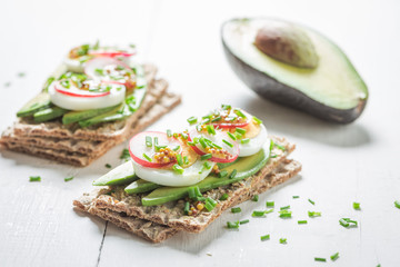 Crispy bread with avocado, chive and eggs for spring breakfast