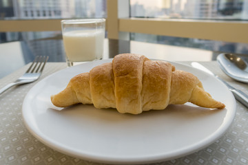 Breakfast with milk and fresh croissants, selective focus