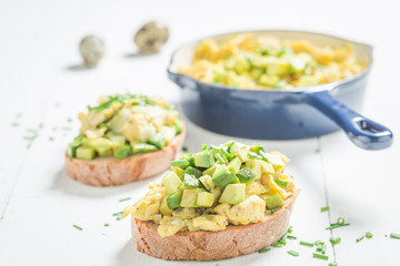 Tasty fried eggs with avocado for breakfast on white table
