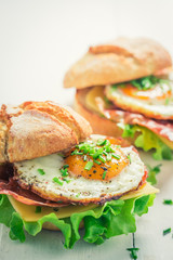 Closeup of fresh burger with lettuce, bacon and eggs