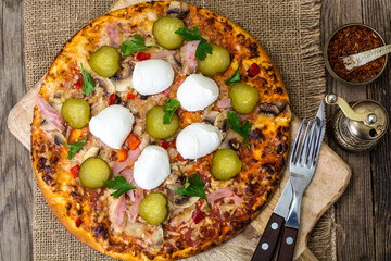 Pizza with ham, mushrooms, gherkin and mozzarella