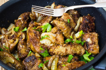 Fried beef liver with onions, curry and spices