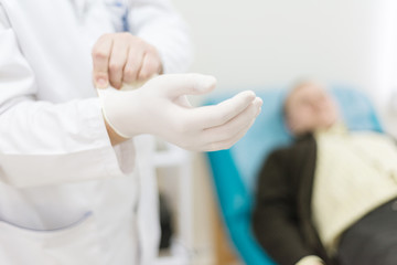 doctor, urologist wears medical gloves while patient waiting