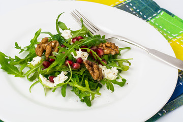 Salad with arugula, pomegranate seeds, feta and walnuts