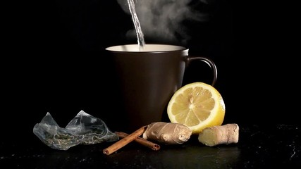 Cup wiht hot water, tea bag, cinnamon, ginger and lemon - Powered by Adobe