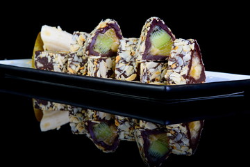 sweet rolls with chocolate and fruit on black background