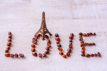 inscription coffee beans word LOVE statue and Eiffel tower on the old wooden light background
