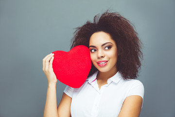 African American young happy girl holding heart shape symbol 