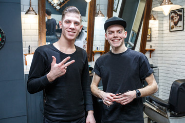 Master cuts hair of men in the barbershop, hairdresser makes hairstyle for a young man