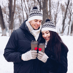 Young couple in park with two paper cup coffee