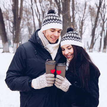 Young Couple In Park With Two Paper Cup Coffee