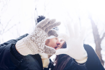 Closeup of couple making heart shape with hands and kissing