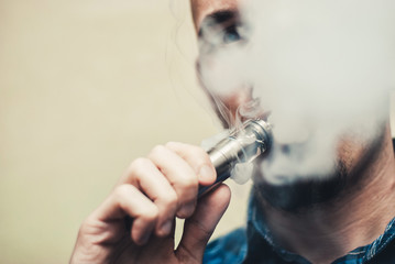 Close up of a man vaping.