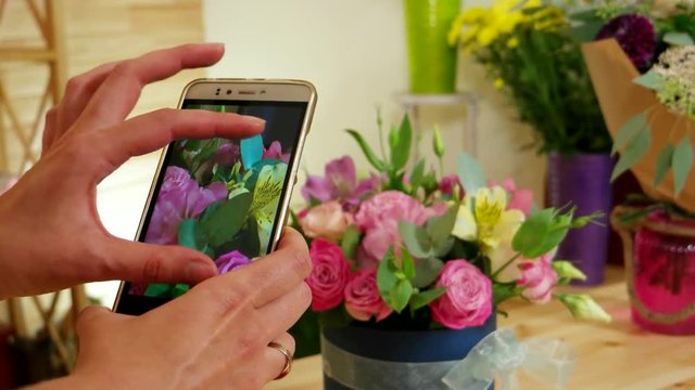 flower arrangements, cell phone takes pictures of the finished bouquet of fresh cut flowers, pictures of flowers, florist photographed on a smartphone in the floral boutique,