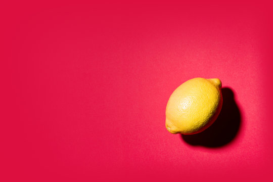 Isolated lemon projecting shadow on red background