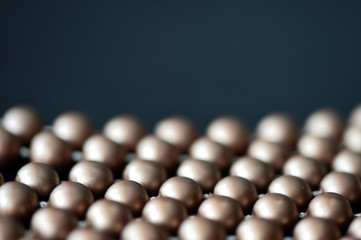 Long necklace made of brown beads on a dark background 