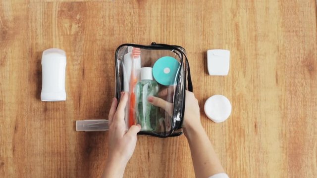 hands packing cosmetic bag for travel