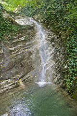Fototapeta na wymiar Горная река превращается в водопад