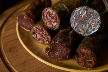 Closeup photo of a different delicacy salami smoked sausage on wooden board