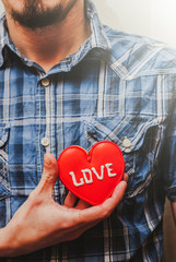 A Man holding a red heart symbol