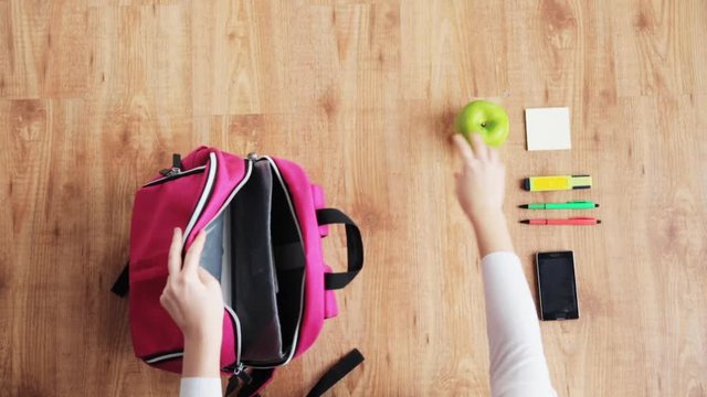 hands packing schoolbag