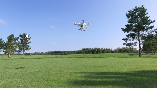 Drone with camera flies up over the golf course.