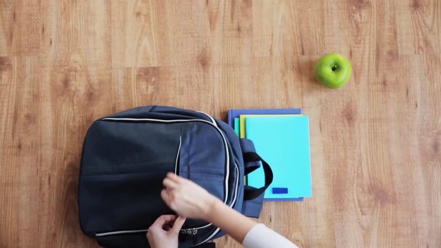 hands packing schoolbag