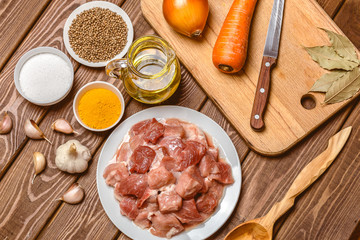 Cooking ingredients: sliced raw meat, oil, spices, garlic, carrot, onion, 