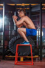Man box jumping at a crossfit style gym.