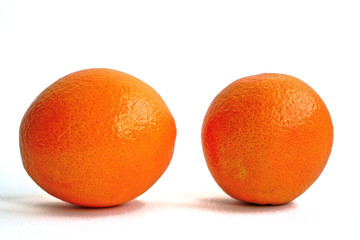 Closeup of two oranges on a white background