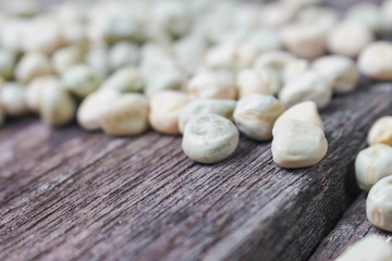 Fototapeta na wymiar dry sugar pea seed, green nuts on the wood board background