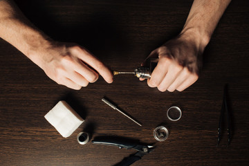 Man repairing e-evaporator,Maintenance of electronic mech mod vaping device.Modern vaporizer e-cig...