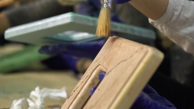 Hands of artists paint frame in a creative workshop. Very beautiful. Slow motion.